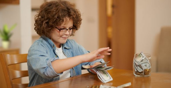 savings-boy-eyeglasses-denim-shirt-counting-his-savings-looking-serious-scaled.jpg